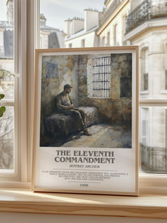 The Eleventh Commandment Bookish Wall Art by Jeffrey Archer – framed print by a bright window