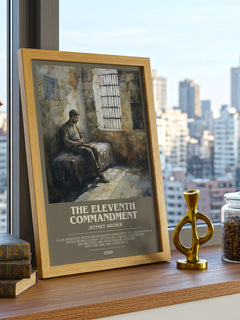 The Eleventh Commandment Bookish Wall Art by Jeffrey Archer – framed print on a city-view windowsill