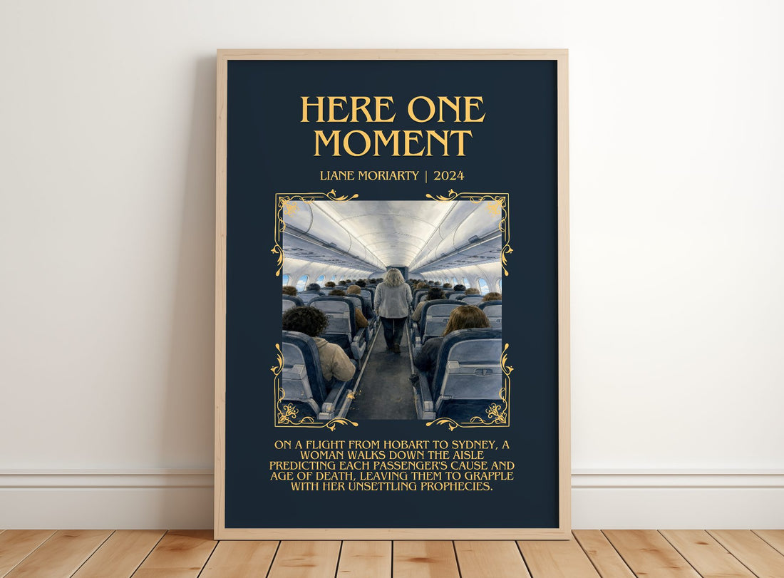Here One Moment Minimalist Book Poster by Liane Moriarty – framed print leaning on a wooden floor