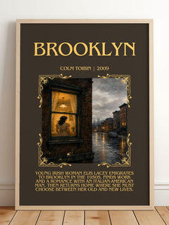 Brooklyn Minimalist Book Poster by Colm Toibin – framed print leaning on a wooden floor