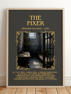 The Fixer Minimalist Book Poster by Bernard Malamud – framed print leaning on a wooden floor
