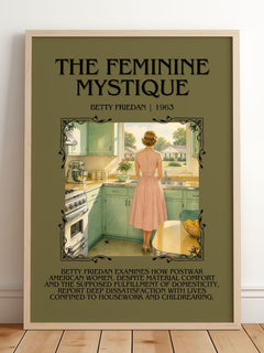 The Feminine Mystique Minimalist Book Poster by Betty Friedan – framed print leaning on a wooden floor