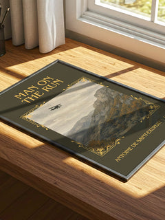 Man On The Run Classic Book Art Print by Antoine De Saint-Exupery – print on a sunlit desk