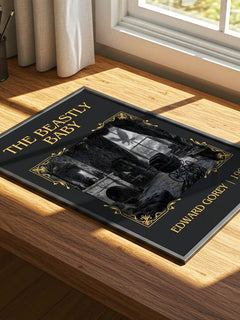 The Beastly Baby Classic Book Art Print by Edward Gorey – print on a sunlit desk