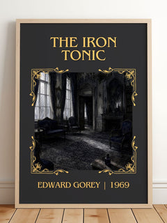 The Iron Tonic Classic Book Art Print by Edward Gorey – framed print leaning on a wooden floor