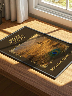 And The Mountains Echoed Classic Book Art Print by Khaled Hosseini – print on a sunlit desk