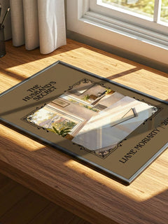The Husband's Secret Classic Book Art Print by Liane Moriarty – print on a sunlit desk
