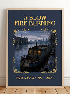 A Slow Fire Burning Classic Book Art Print by Paula Hawkins – framed print leaning on a wooden floor