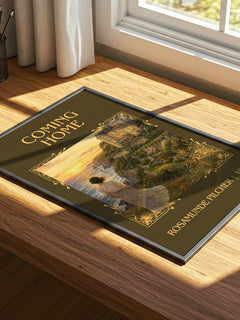 Coming Home Classic Book Art Print by Rosamunde Pilcher – print on a sunlit desk