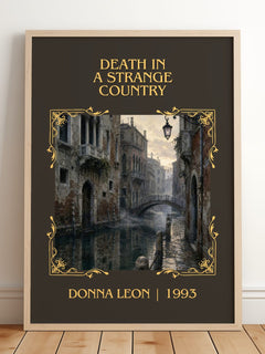 Death in a Strange Country Classic Book Art Print by Donna Leon – framed print leaning on a wooden floor