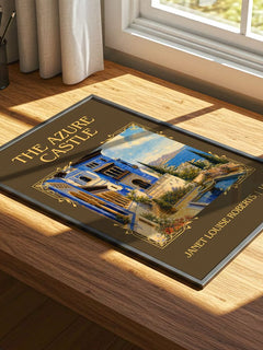 The Azure Castle Classic Book Art Print by Janet Louise Roberts – print on a sunlit desk