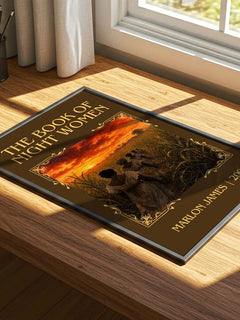 The book of night women Classic Book Art Print by Marlon James – print on a sunlit desk