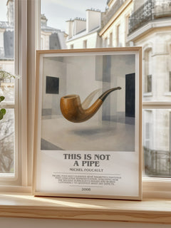 This Is Not a Pipe Bookish Wall Art by Michel Foucault – framed print by a bright window