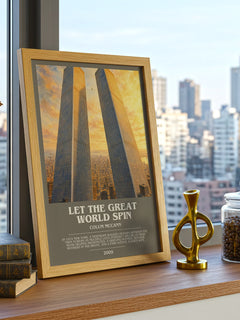 Let the Great World Spin Bookish Wall Art by Colum McCann – framed print on a city-view windowsill