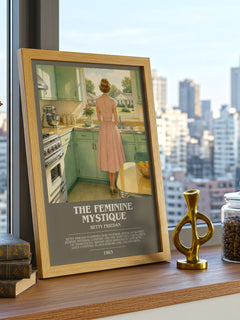 The Feminine Mystique Bookish Wall Art by Betty Friedan – framed print on a city-view windowsill